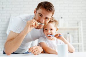 歯を磨いている父子