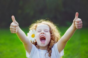 ウエーブヘアの女の子が耳上に花を挿しグッドポーズをしている