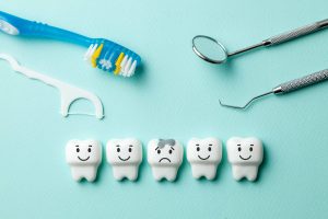 健康な歯と虫歯になっている歯、歯ブラシ、歯の治療器具が置かれている