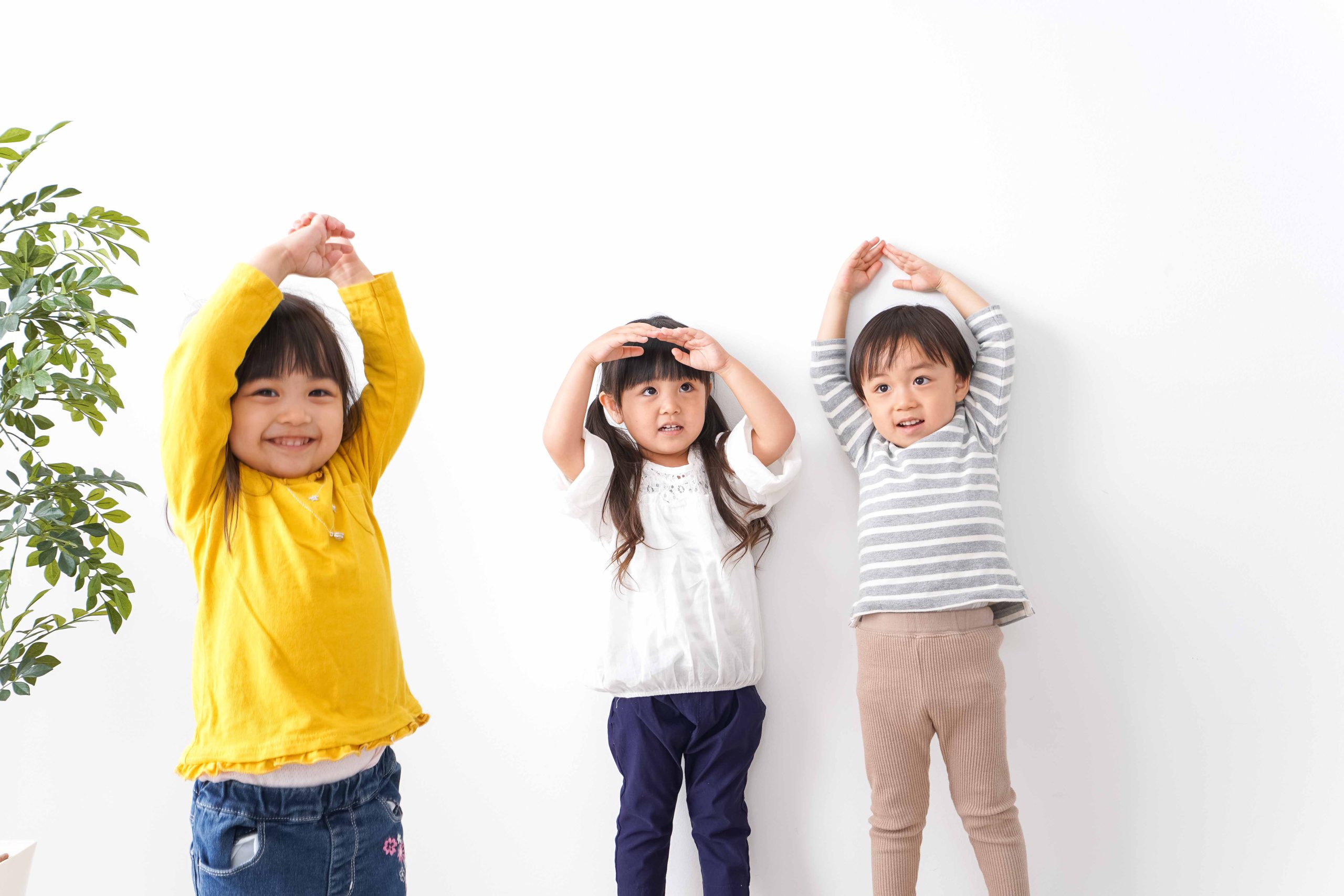 3人の子が笑顔で遊んでいる