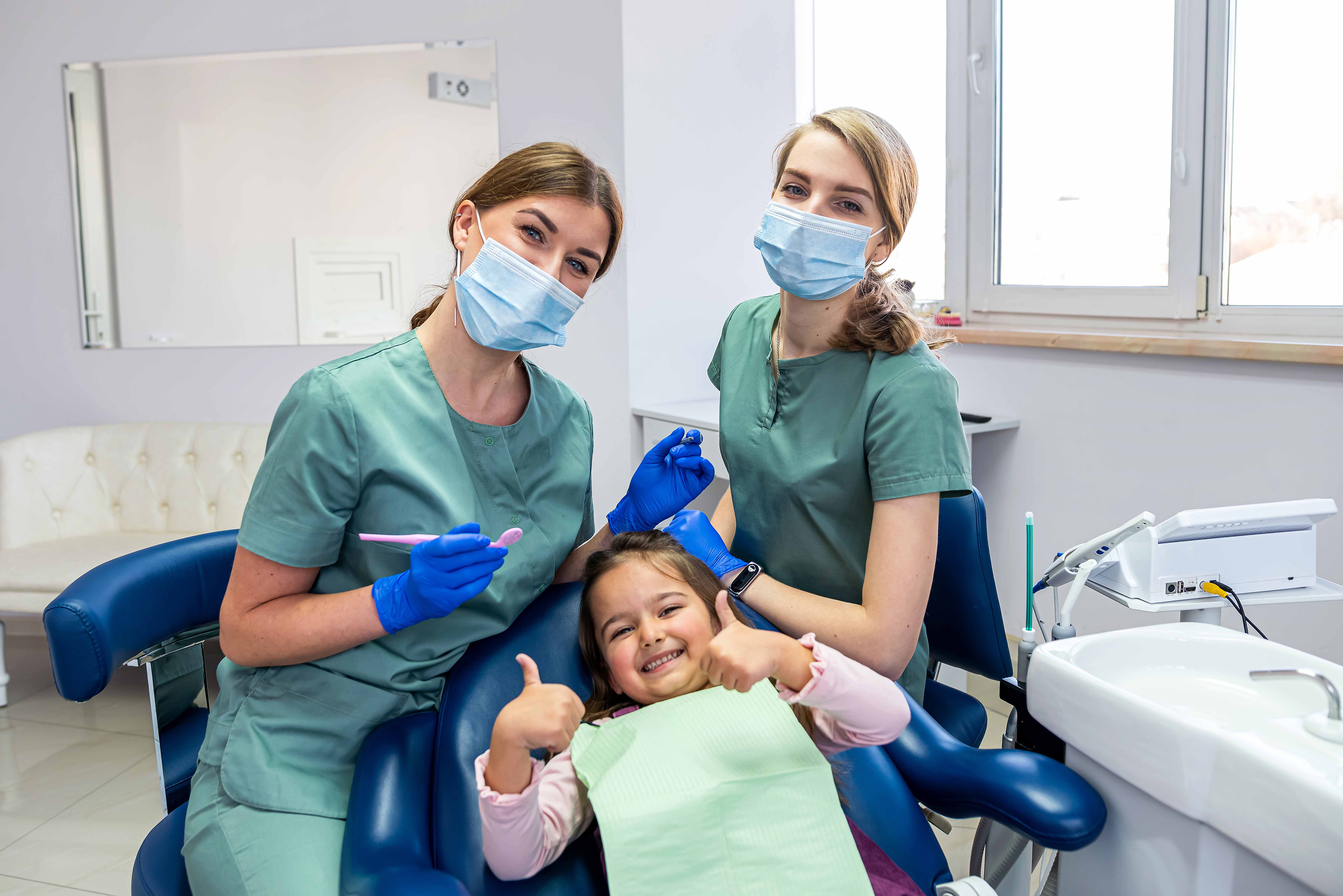 歯科の椅子に座る女の子と女性歯科医師